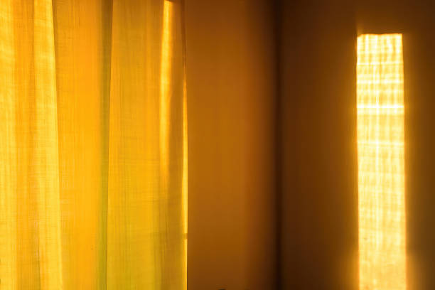 istock Sunbeam on yellow wall of house. Surface texture with sun glare. 1443371977