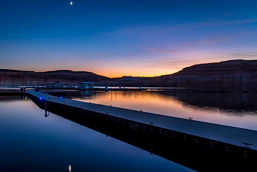 Beautiful view of sunset reflection on the water and boat dock Hall's Crossing and Bullfrog marinas at Lake Powell reservoir in Utah and Arizona.  Part of Colorado River in the Glen Canyon National Recreation Area.