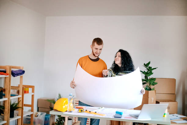 Young couple working together on finding best solution for new apartment stock photo