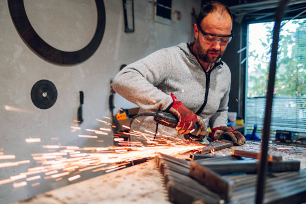 istock Worker in a factory grinding metal with a grinder 1443381589