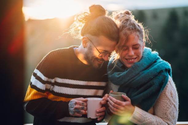 istock Young couple drinking coffee or tea while standing on their balcony at sunrise 1443381614