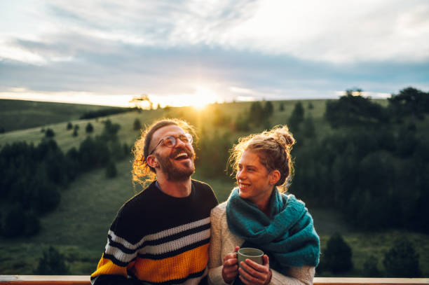 istock Young couple drinking coffee or tea while standing on their balcony at sunrise 1443381615