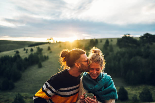 istock Young couple drinking coffee or tea while standing on their balcony at sunrise 1443381618