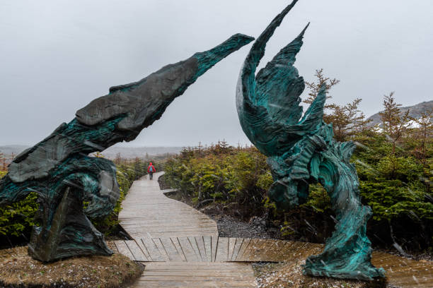Newfoundland, Canada - June 13, 2018:  A woman walking on footpath in snowing.  L'Anse aux Meadows, on the northern tip of Newfoundland, is the only known site of a Norse village in Canada.