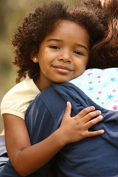 Little girl hugging her mother stock photo
