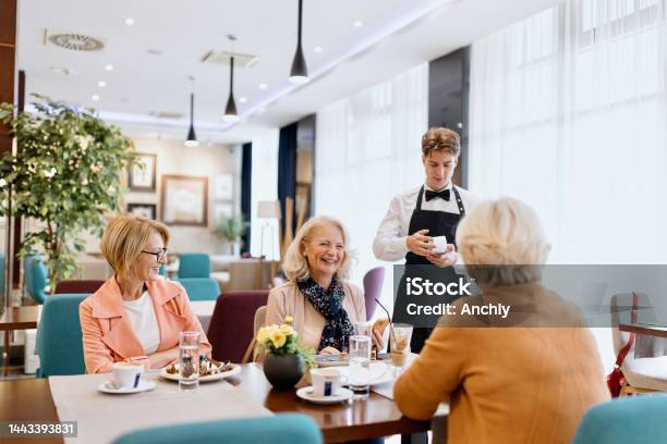 Senior Woman Making A Contactless Payment At A Restaurant Using Her Cell Phone Stock Photo - Download Image Now
