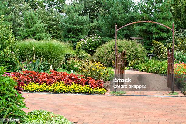 Formal Garden With Red Brick Pathway And Rustic Open Gate Stock Photo - Download Image Now