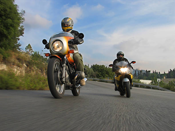 leaning into the curve two motorcycles turning on a scenic road motorized vehicle riding stock pictures, royalty-free photos & images