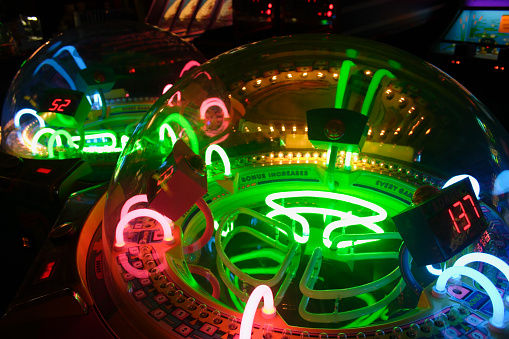 An arcade game lit up with multi-colored lights