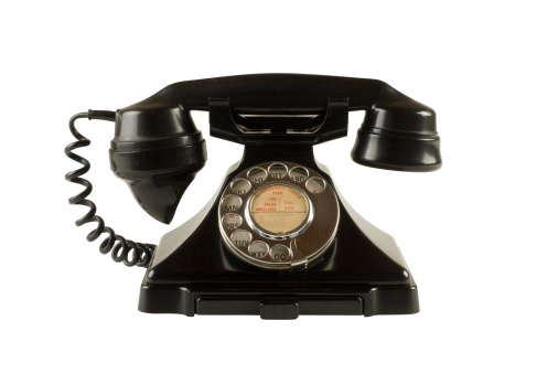 Old 1950s bakelite dial telephone isolated on white with clipping path.