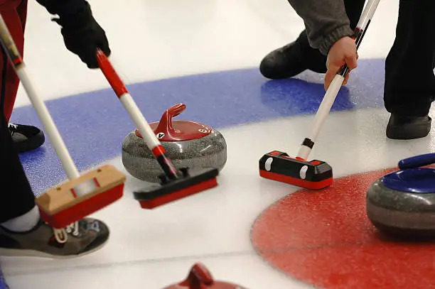Curling Action with sweepers and rock