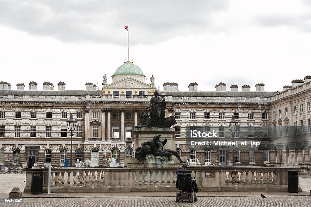 Homme en fauteuil roulant en face de la fontaine de Somerset House, Londres - Photo de Palais de justice libre de droits