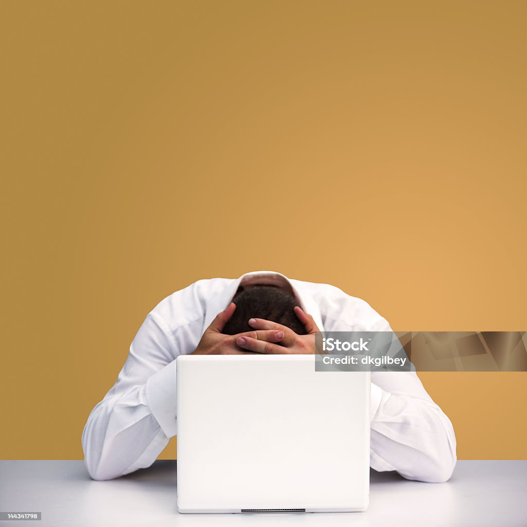 A man hanging head over laptop Man holding his head in his hands in despair at what has happened... Includes clipping path, so you can change the background easily if you want. Adult Stock Photo