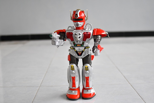 Red robot toy with gun and bazooka in the floor