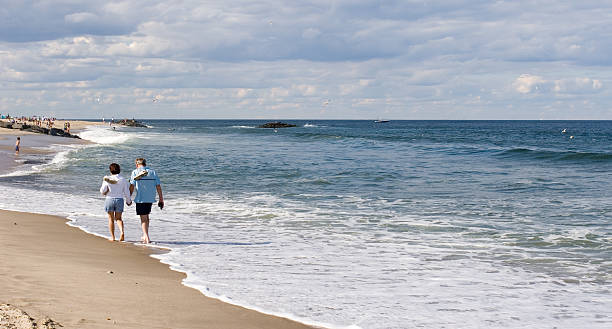 istock Couple walking along the beach 144342199