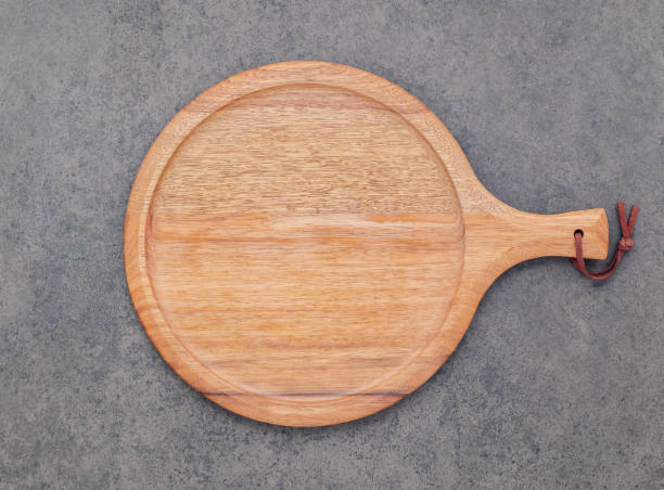 istock Empty wooden pizza platter set up on dark stone background . Pizza board on stone background flat lay and copy space. 1443423361