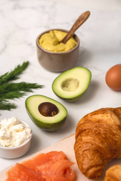 istock Fresh morning croissants with avocado on table. Top view. 1443425751