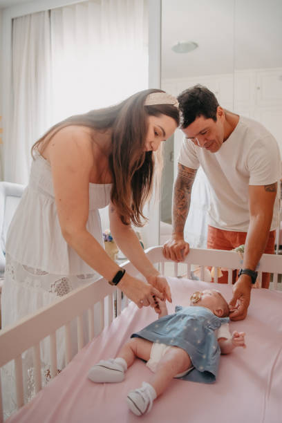 istock parents admiring their baby in crib 1443426151