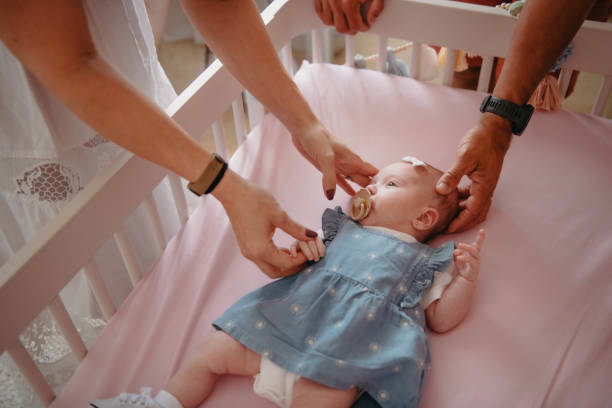 istock parents admiring their baby in crib 1443426176