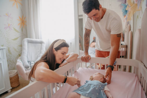 istock parents admiring their baby in crib 1443426237