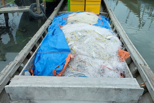 Piles of used fishing nets that have been placed one on top of the other in the boat