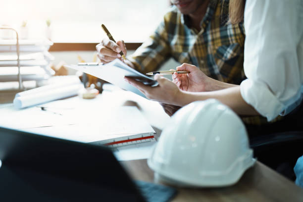 istock Engineers are consulting the team to design an architectural structure for clients with blueprints and building models to work at office 1443431791