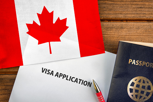 Visa application form, passport and flag of Canada