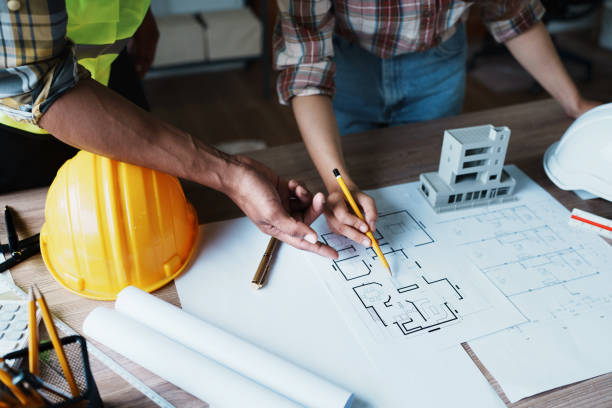 istock Engineers are consulting the team to design an architectural structure for clients with blueprints and building models to work at office 1443432900