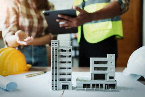 istock Engineers are consulting the team to design an architectural structure for clients with blueprints and building models to work at office 1443433046