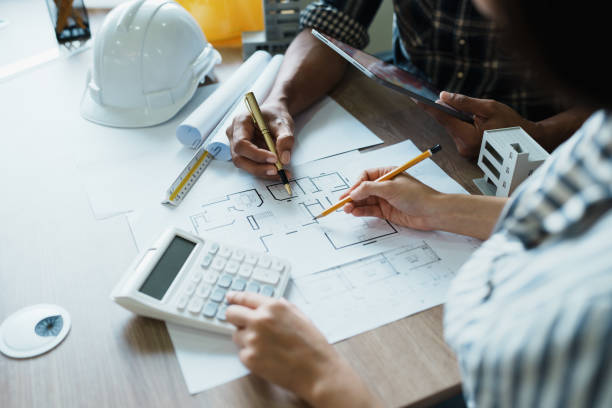 istock Engineers are consulting the team to design an architectural structure for clients with blueprints and building models to work at office 1443433268