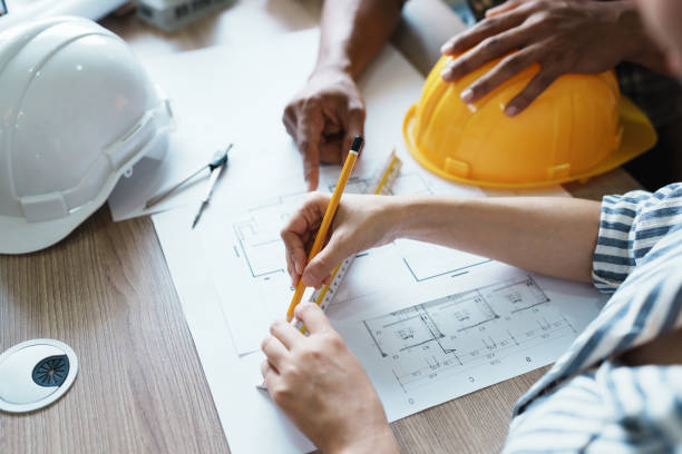 istock Engineers are consulting the team to design an architectural structure for clients with blueprints and building models to work at office 1443434027