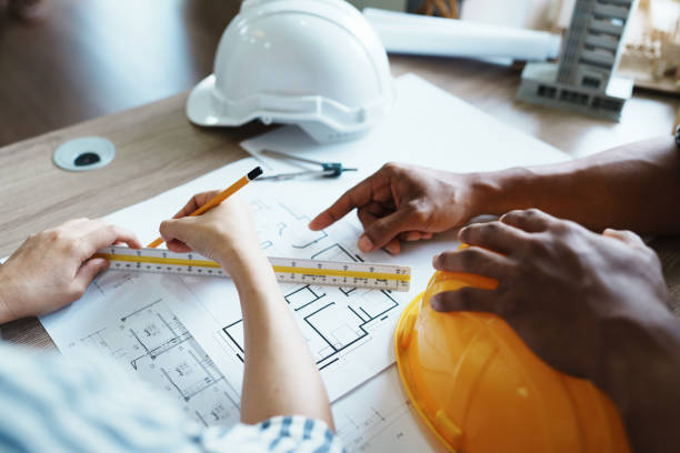 istock Engineers are consulting the team to design an architectural structure for clients with blueprints and building models to work at office 1443434044