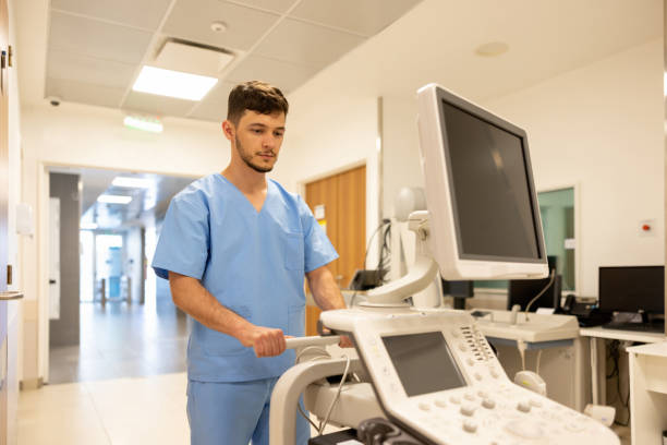 медсестра с аппаратом сонограммы в больнице - male nurse male healthcare and medicine technician стоковые фото и изображения
