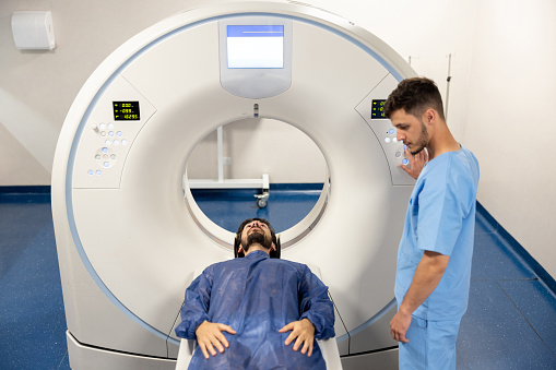 Man getting ready for an MRI scan at the hospital - healthcare and medicine concepts