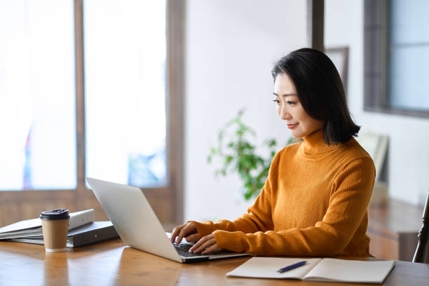 Asian woman typing on a computer stock photo