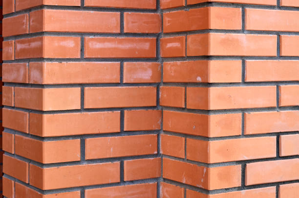 istock Bricks wall with different orange tones to be used as a background texture, digital graffiti or construction industry example. It is an image that shows solidity, strength, the human capacity. 1443436844