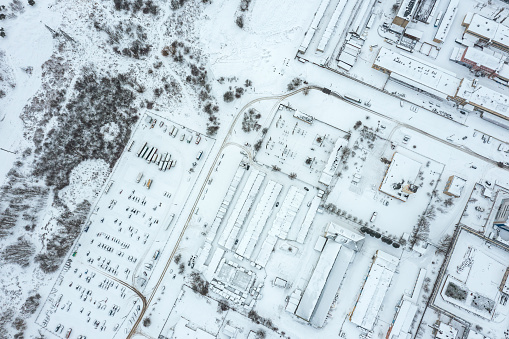 winter parking lot with cars covered with snow. industrial area. view from above.
