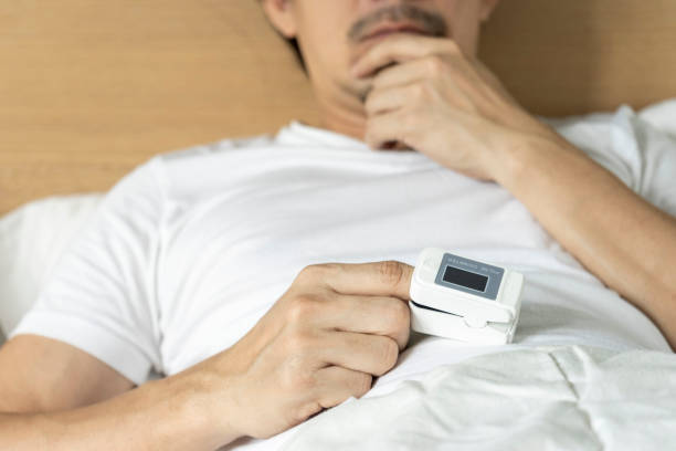istock View of male patient using oximeter on finger lying in bed. 1443440033