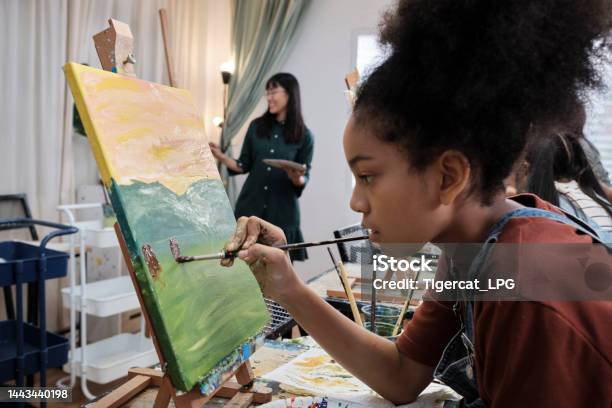 A Girl Concentrates On Acrylic Color Painting On Canvas In An Art Classroom Stock Photo - Download Image Now