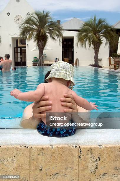 Foto de Pai Segurando O Bebê Com Chapéu Na Beira Da Piscina e mais fotos de stock de Atividades de Fins de Semana