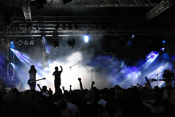 Crowd view of concert with purple lights and fog stock photo