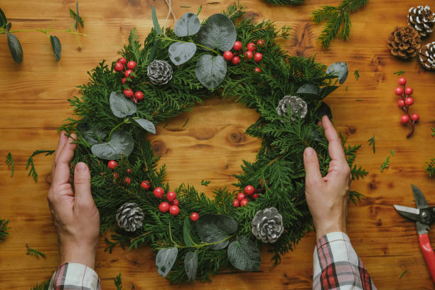 istock Female hands hold Christmas wreath. 1443447963