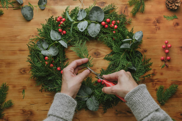istock Woman making Christmas wreath. DIY winter home decor. 1443447965