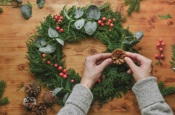 istock Female hands making Christmas wreath. DIY winter home decoration. 1443447970