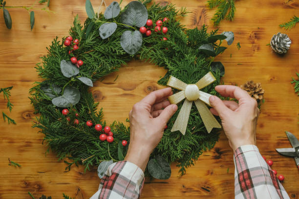 istock Hands decorating Christmas wreath with ribbon. 1443447976