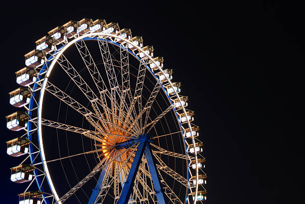 istock illuminated ferris wheel at night against dark sky 144345439