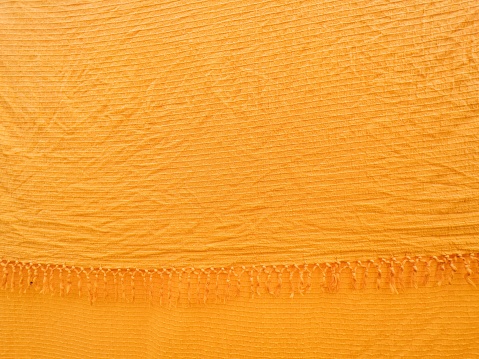 Orange textile material as background, crumpled fabric texture