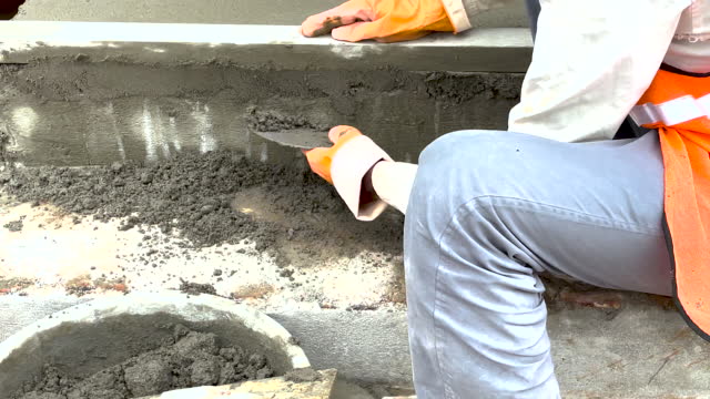 Builder plastering cement at the wall for building a house