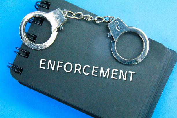 istock notebooks and handcuffs with the word enforcement 1443457452