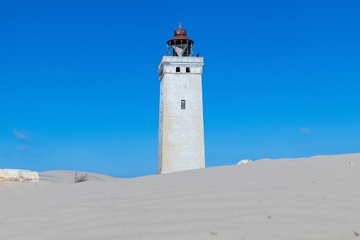The iconic lighthouse Rubjerg Knude Fyr in the dunes of northern Denmark on a summer day